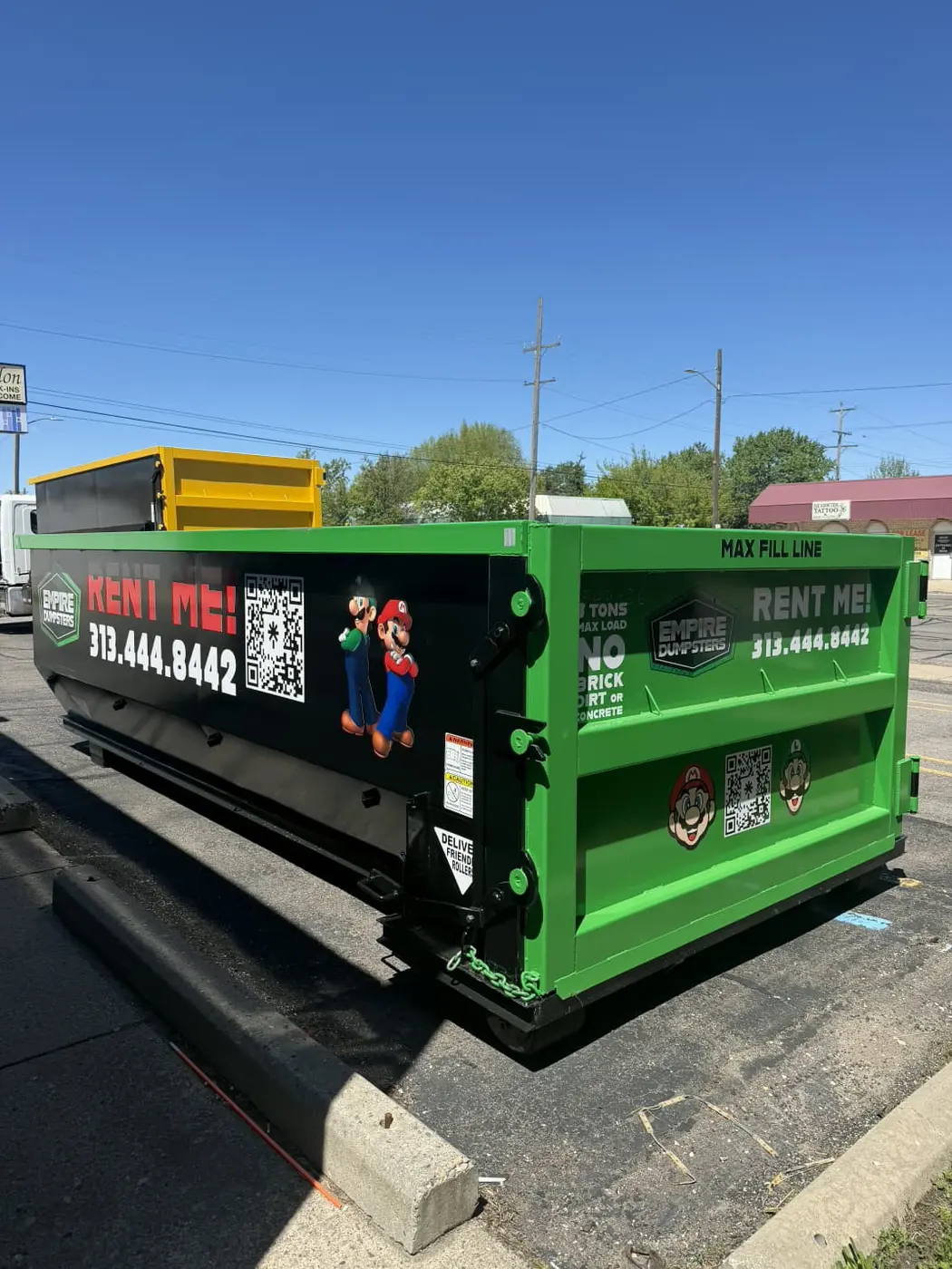 Green Empire Dumpsters roll-off dumpster with Mario and Luigi characters on the side panels